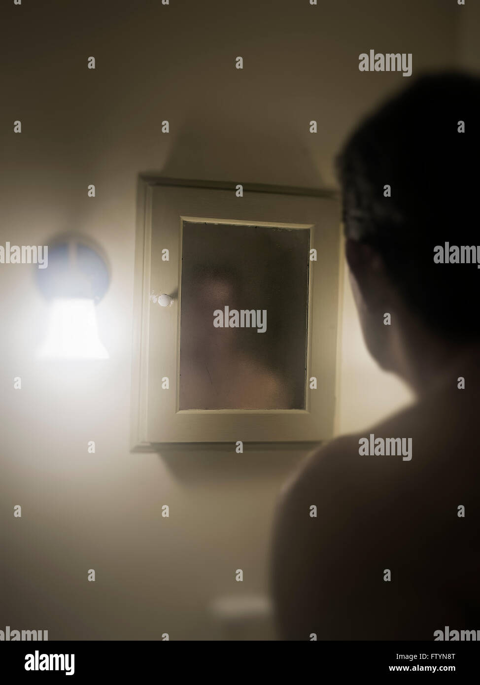L'uomo affronta il suo oscuro immagine allo specchio. Foto Stock
