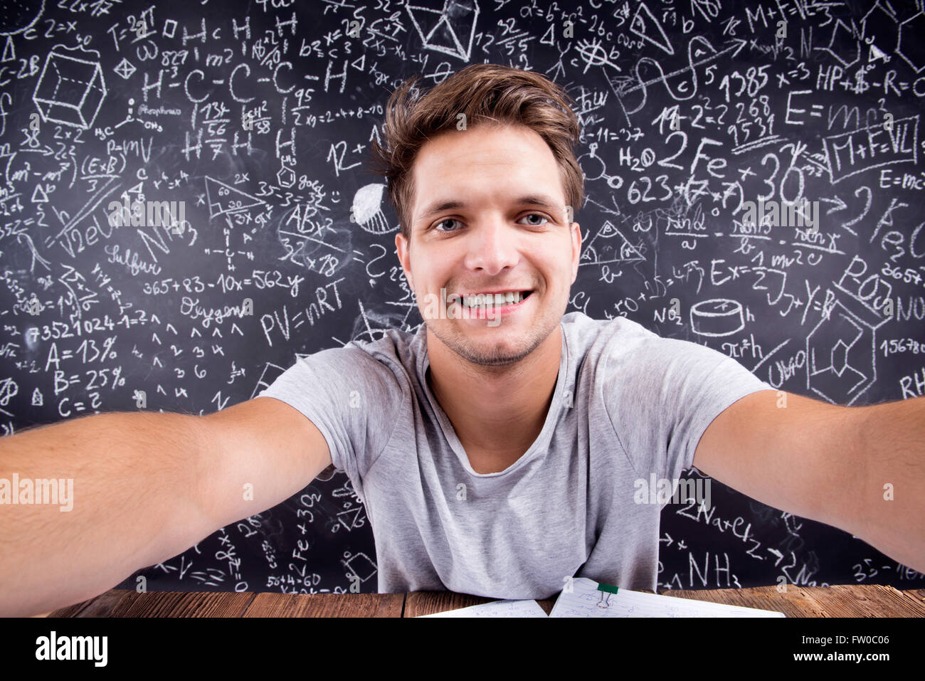 Hipster studente facendo prendendo selfie contro una grande lavagna Foto Stock