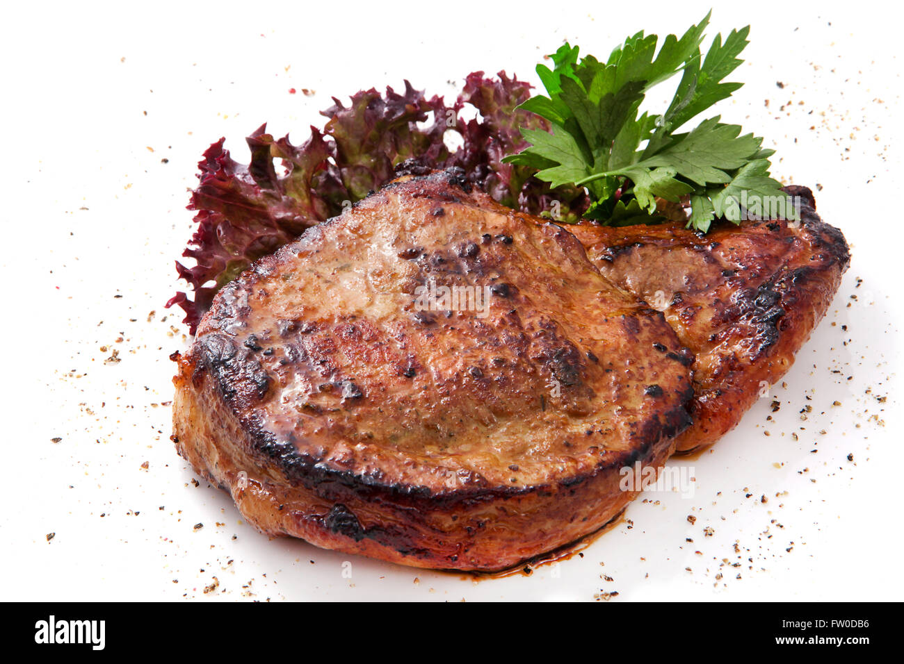 Bistecca di carne di maiale con verdure, erbe aromatiche e pepe Foto Stock