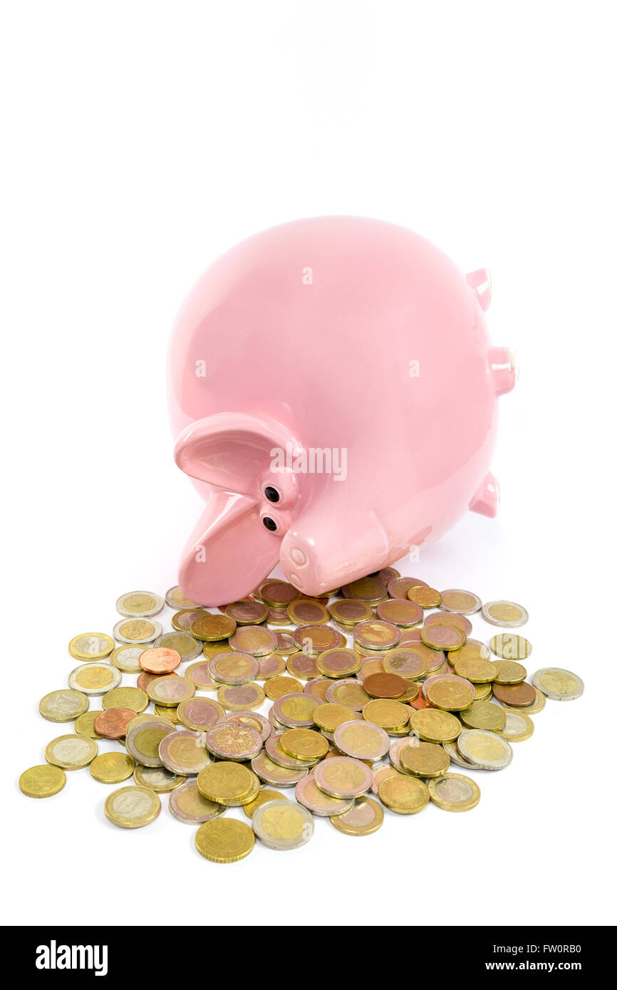 Giacente rosa salvadanaio con la pila di monete in euro isolati su sfondo bianco Foto Stock