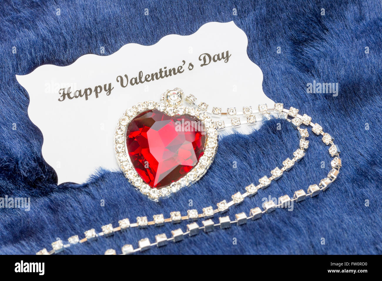Rosso collana di gioielli con il messaggio di San Valentino card isolato sul panno blu sullo sfondo Foto Stock