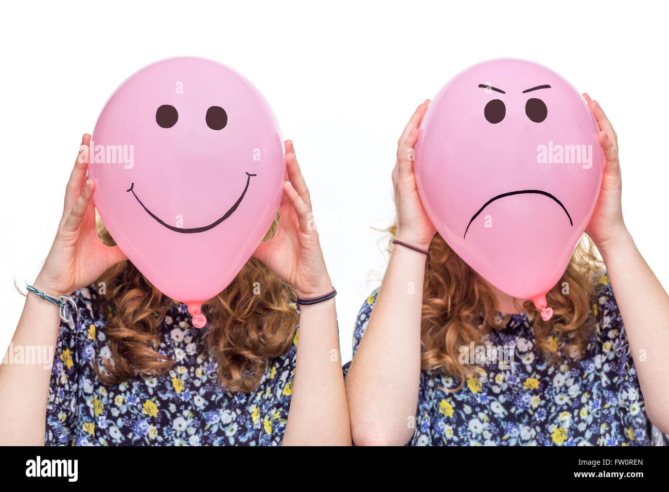 Due donne azienda palloncini rosa con felice e arrabbiato le espressioni del viso per le loro teste isolati su sfondo bianco Foto Stock