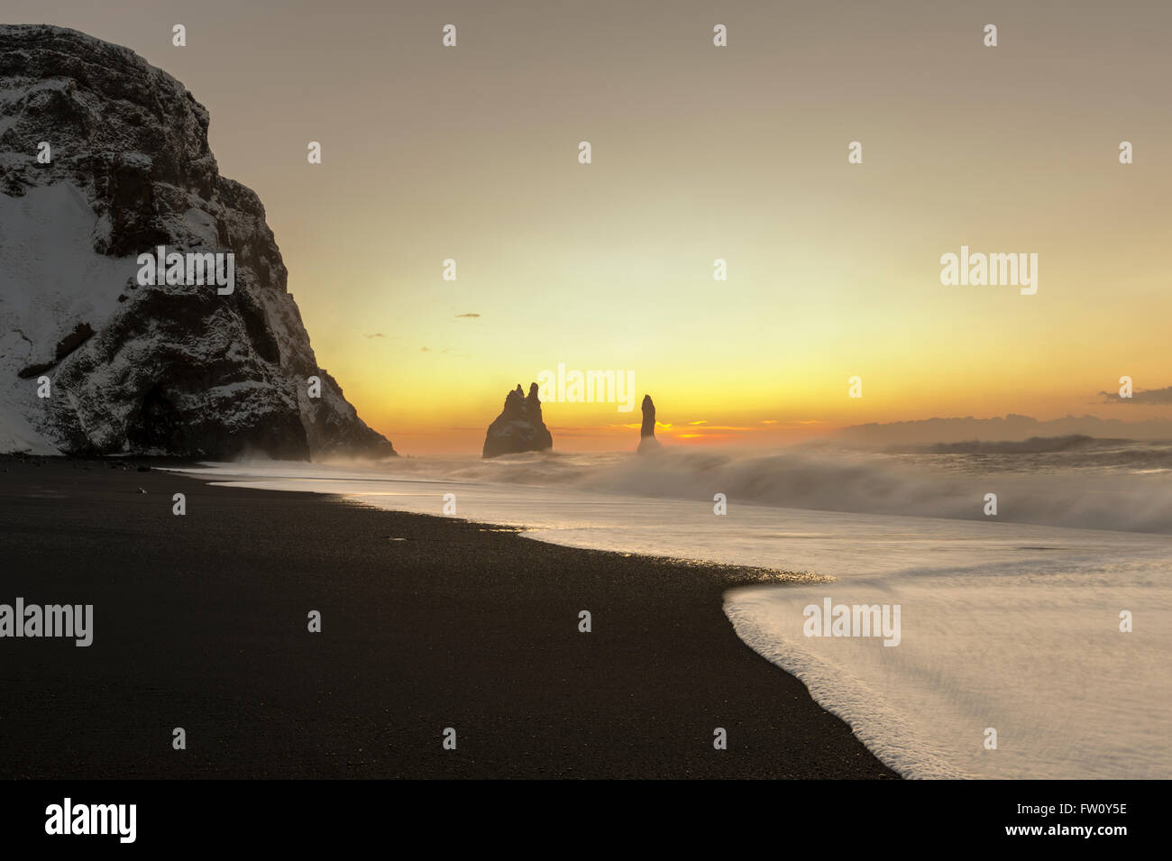 Reynisdrangar basalto pile di mare e il Reynisfjara spiaggia di sabbia nera vicino al villaggio di Vík í Mýrdal, Sud dell'Islanda Foto Stock