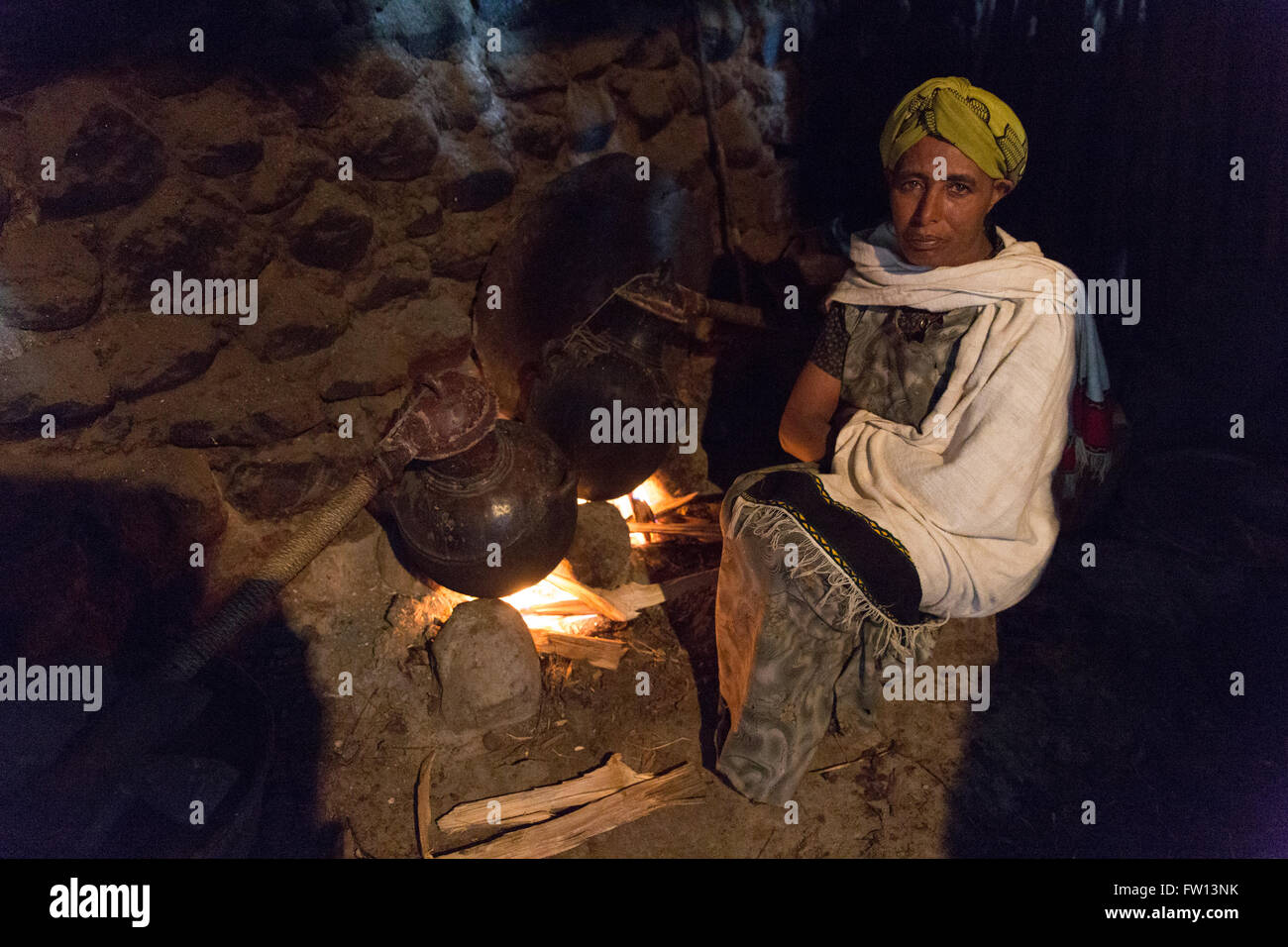 Furamariam, villaggio, Debele, Amhara, Etiopia, Ottobre 2013: Kidane Wolde la moglie Amarich rende Araki a vendere. Fotografia di Mike Goldwater Foto Stock