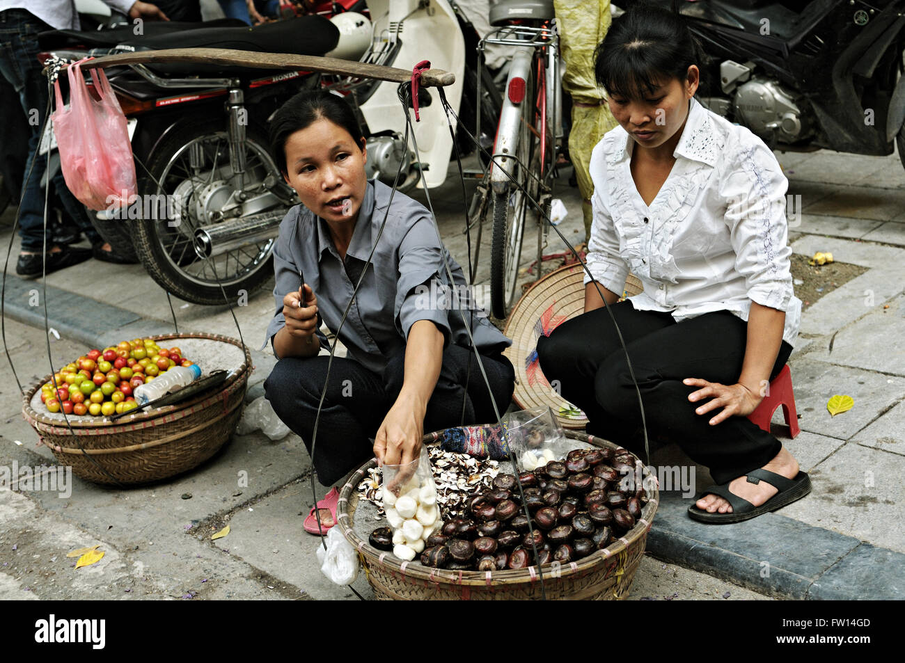 Il vietnamita le donne vendono frutti nel quartiere vecchio di Hanoi, Vietnam Foto Stock