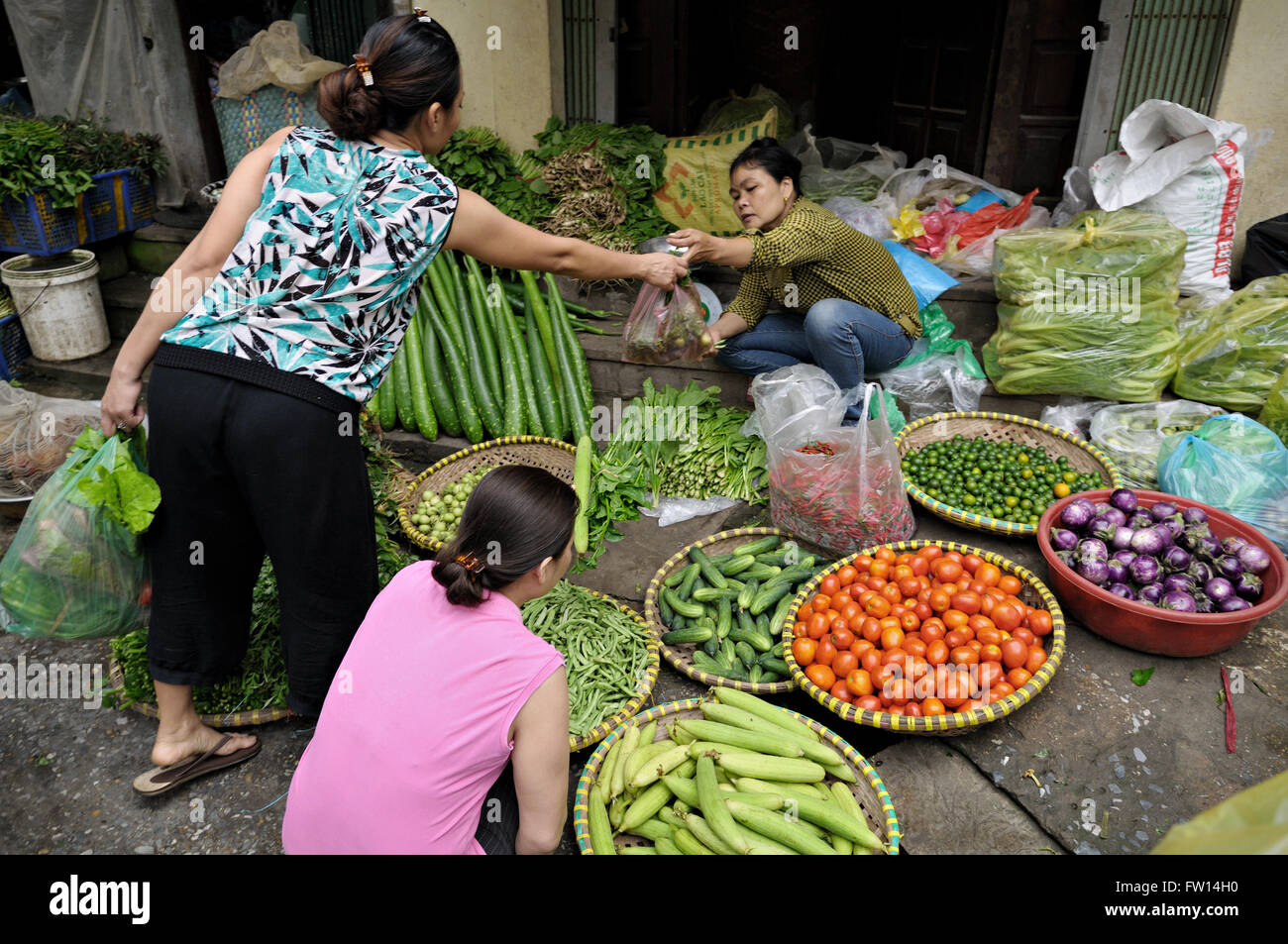 Donna vendita di verdure al mercato nel quartiere vecchio di Hanoi, Vietnam Foto Stock