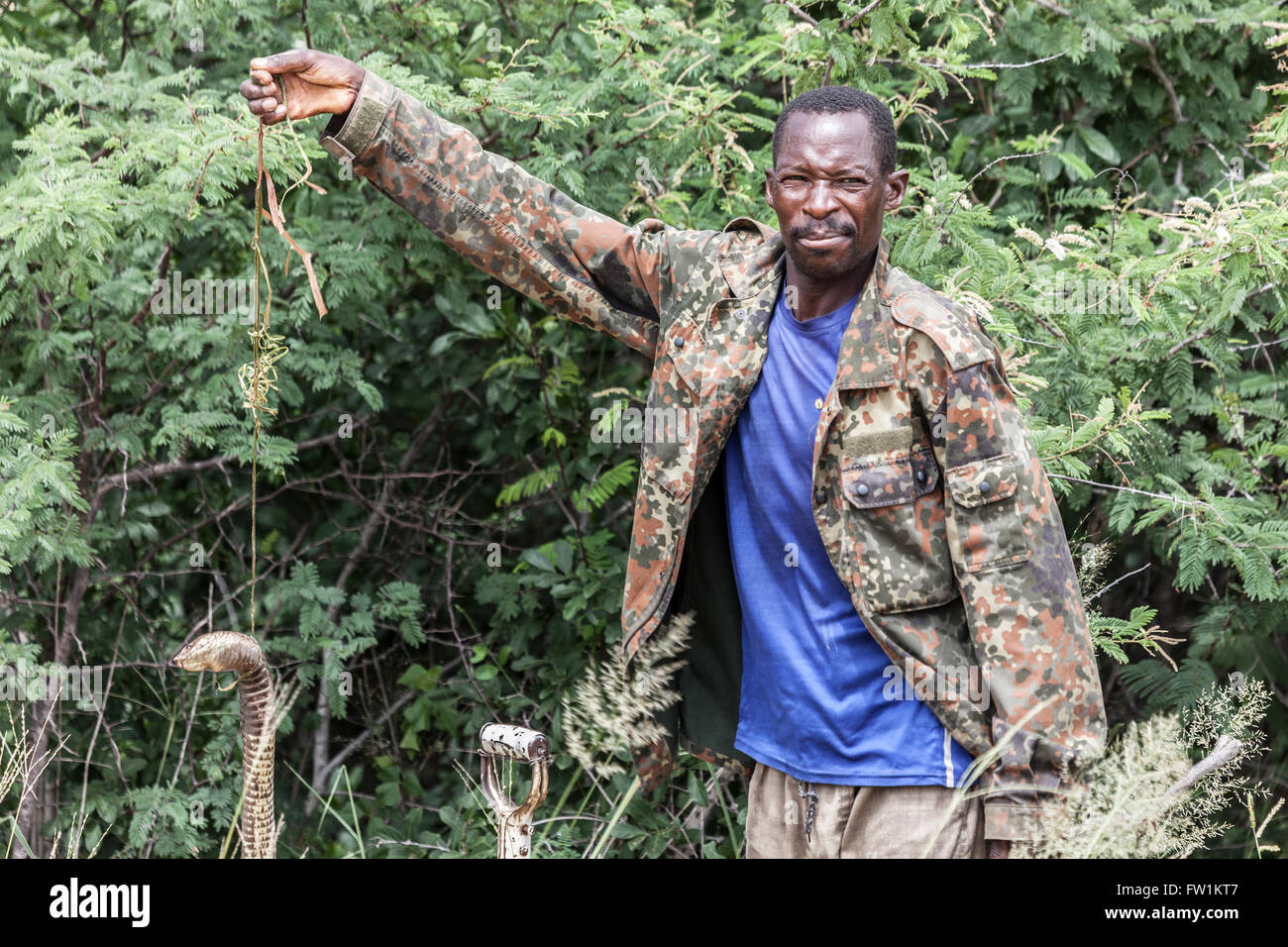 Un abitante della Namibia vicino alla Autostrada Trans-Kalahari mostra off un serpente velenoso che ha ucciso nei pressi della sua casa e sta per seppellire. Foto Stock