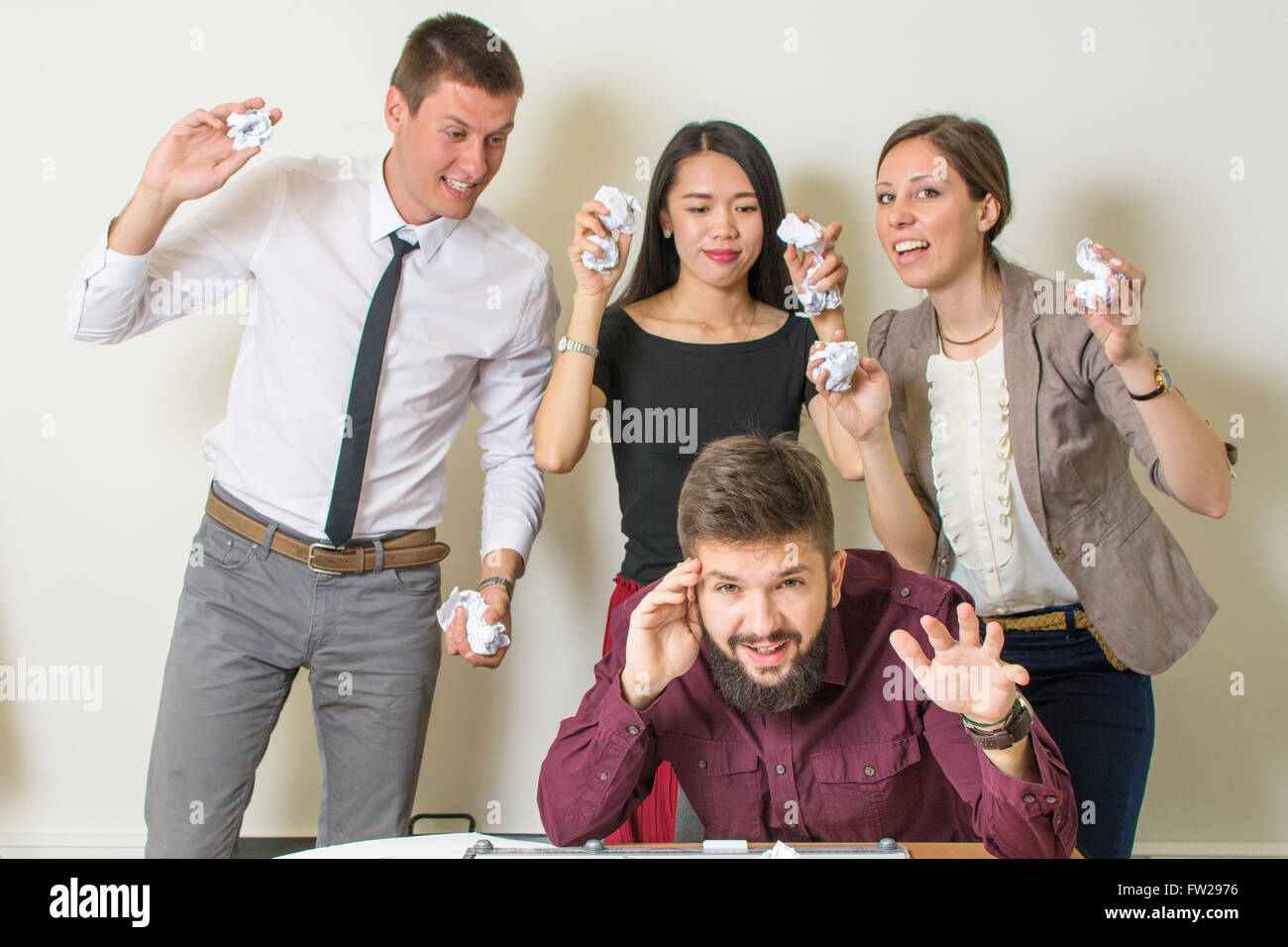 Persone che lanciano sui documenti di un collega in ufficio Foto Stock