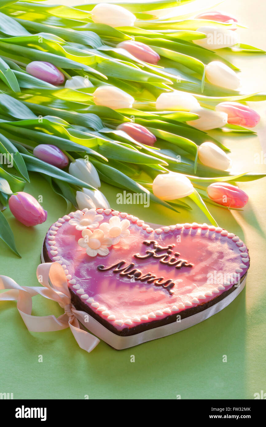 Torta rosa con scritte che dice Für Mama, per la mamma per la Festa della Mamma con fiori Foto Stock