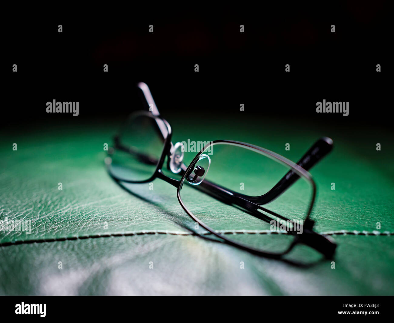 Gli occhiali da lettura sulla poltrona in pelle, la profondità di campo Foto Stock