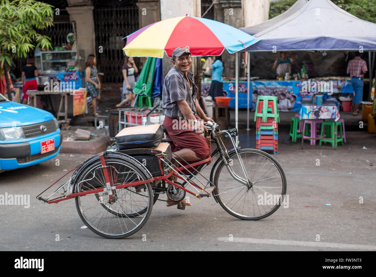 YANGON, MYANMAR - Gennaio 3, 2016: Unidentified uomo a cavallo di un riscio' per le strade di Yangon , il Myanmar il 3 gennaio 2016 Foto Stock