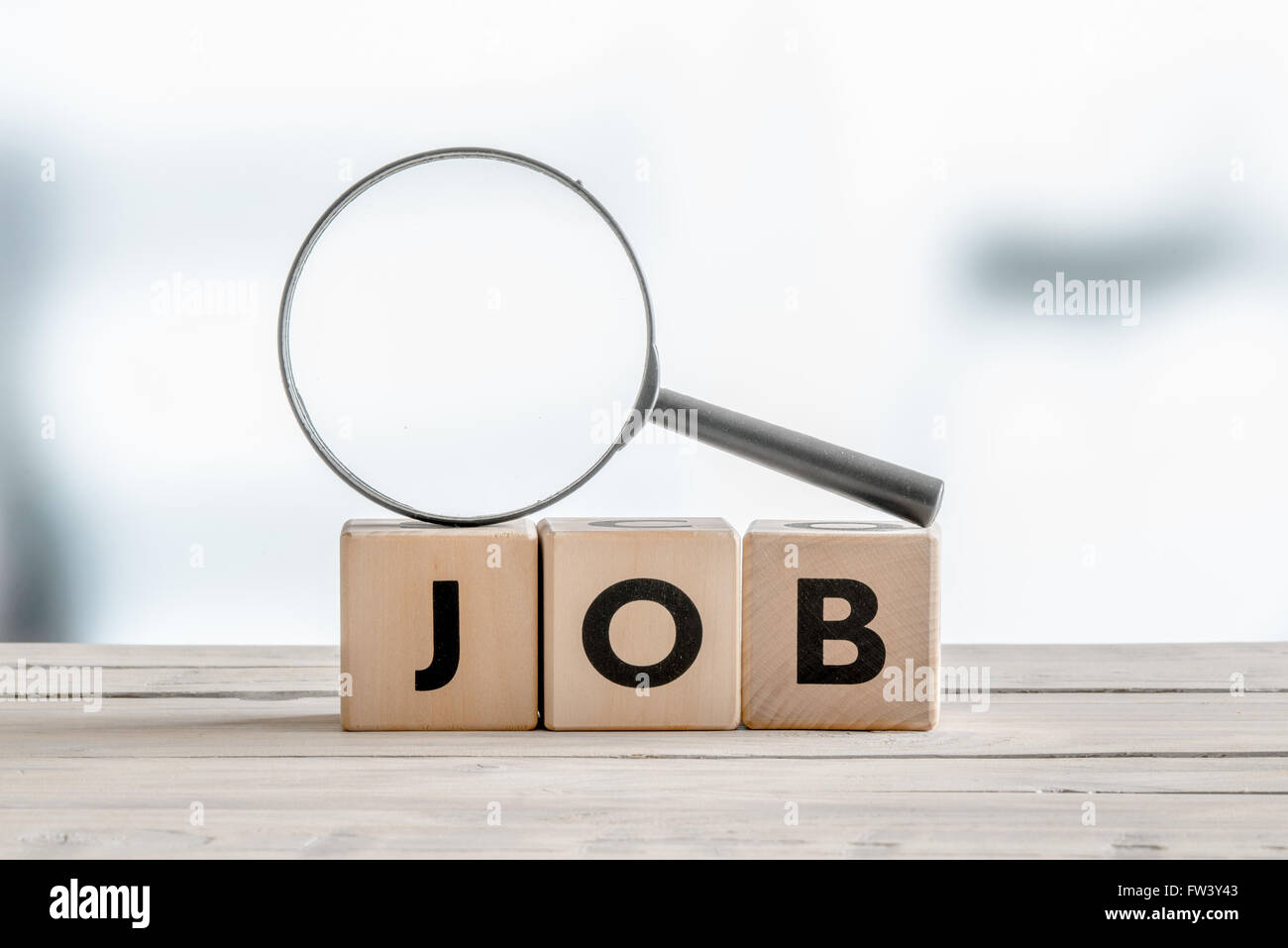 Lente di ingrandimento sulla parola lavoro su una tavola di legno Foto Stock