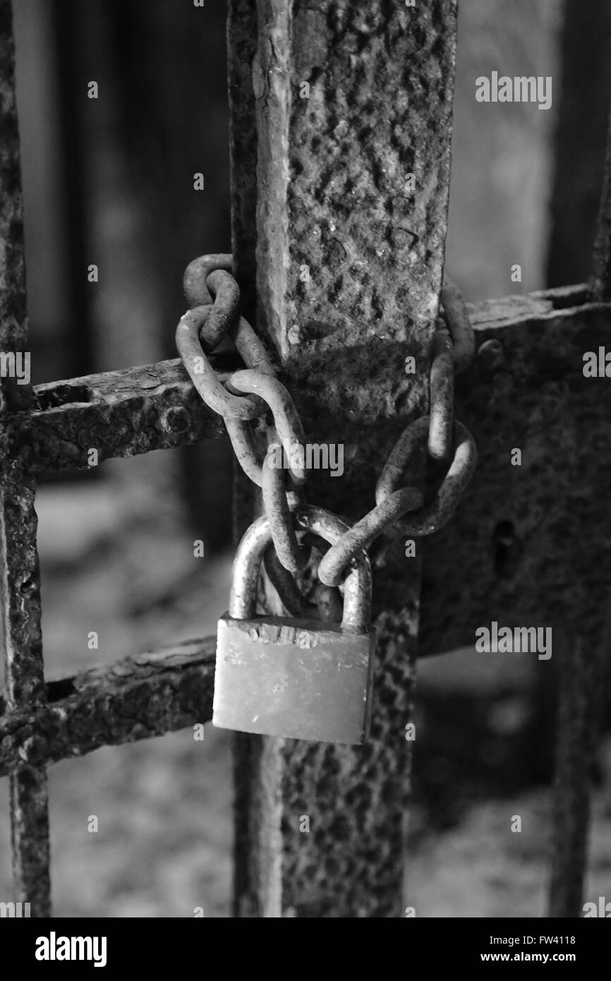 Grande vecchio arrugginito il lucchetto con la catena e la porta della prigione Foto Stock