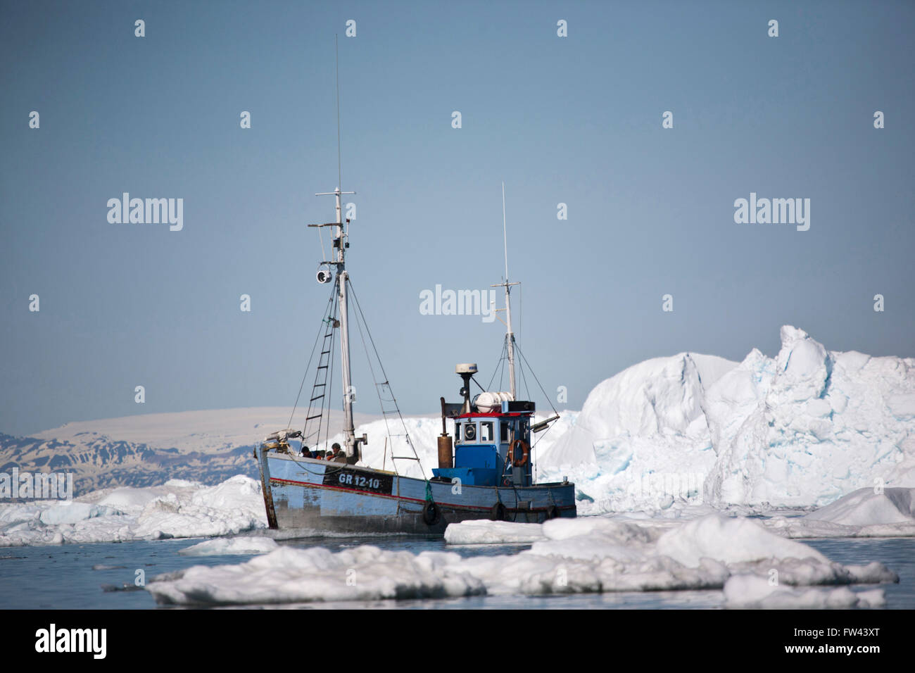 Una barca da pesca tra gli iceberg in Groenlandia Foto Stock