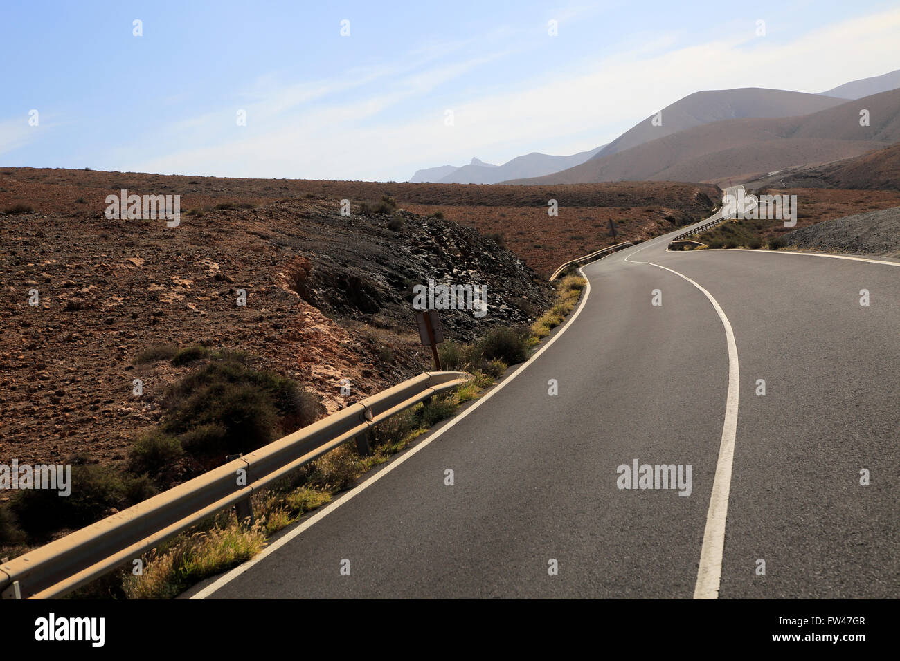 Su strada asfaltata attraversando il deserto arido terreno montuoso tra Pajara e La Pared, Fuerteventura, Isole Canarie, Spagna Foto Stock