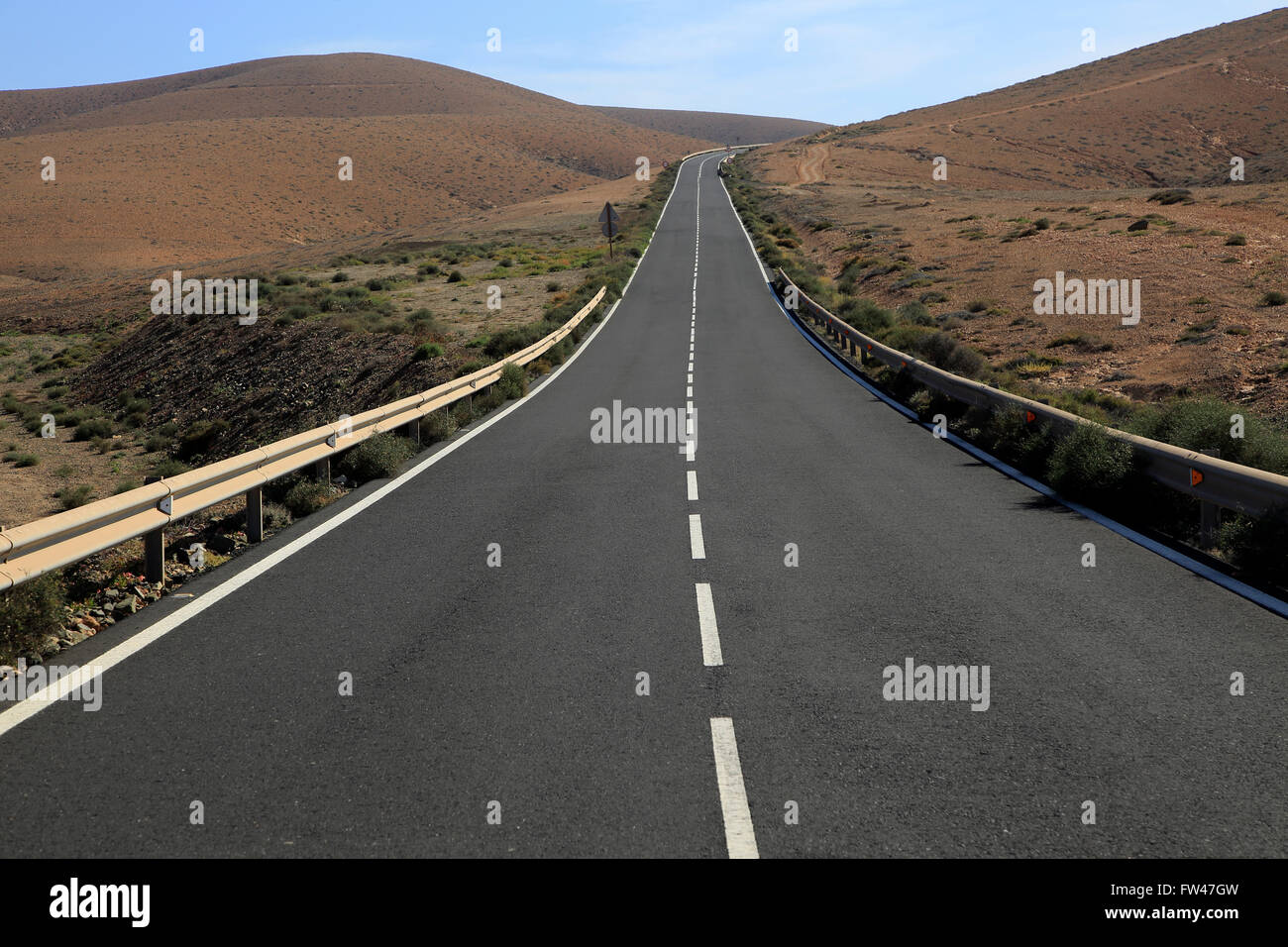 Su strada asfaltata attraversando il deserto arido terreno montuoso tra Pajara e La Pared, Fuerteventura, Isole Canarie, Spagna Foto Stock