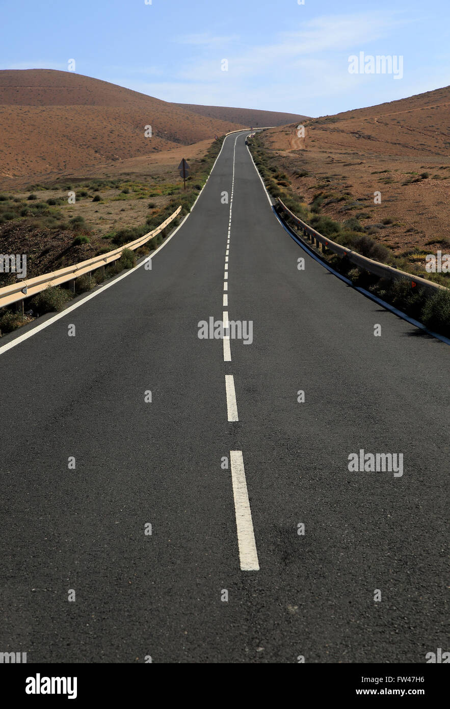 Su strada asfaltata attraversando il deserto arido terreno montuoso tra Pajara e La Pared, Fuerteventura, Isole Canarie, Spagna Foto Stock