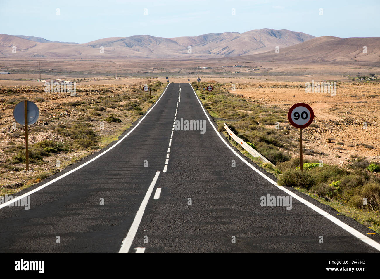 Dritto su strada asfaltata attraversando il deserto, Fuerteventura, Isole Canarie, Spagna Foto Stock