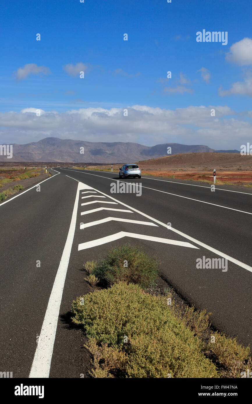 Chevron road linee sulla principale autostrada attraverso Malpaís Grande parco nazionale, Fuerteventura, Isole Canarie, Spagna Foto Stock