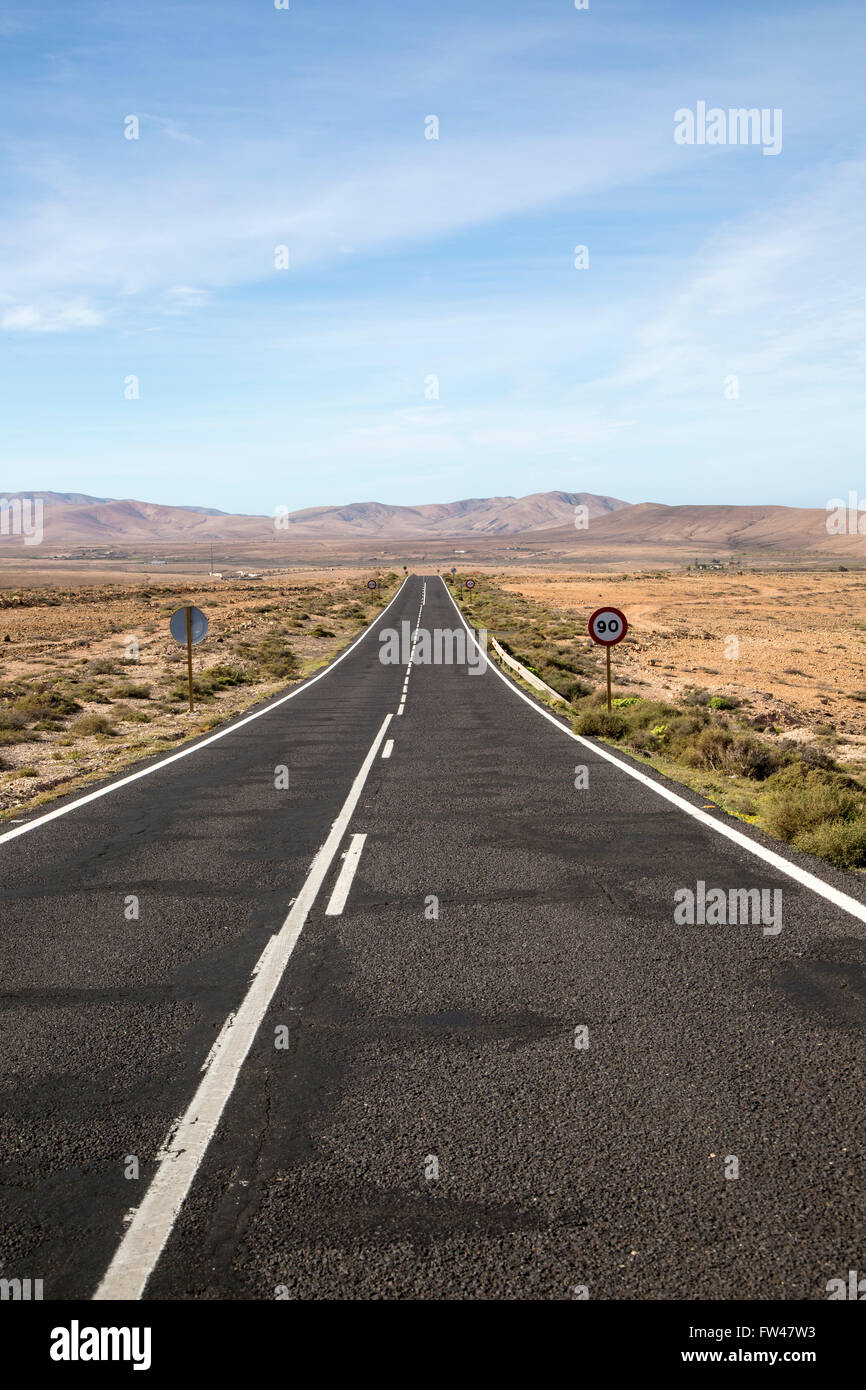 Dritto su strada asfaltata attraversando il deserto, Fuerteventura, Isole Canarie, Spagna Foto Stock