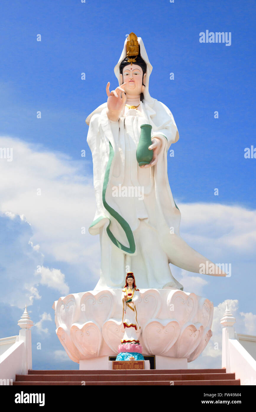 La statua della dea Guan Yin in Wat Thailandia. Cielo blu sullo sfondo. Foto Stock