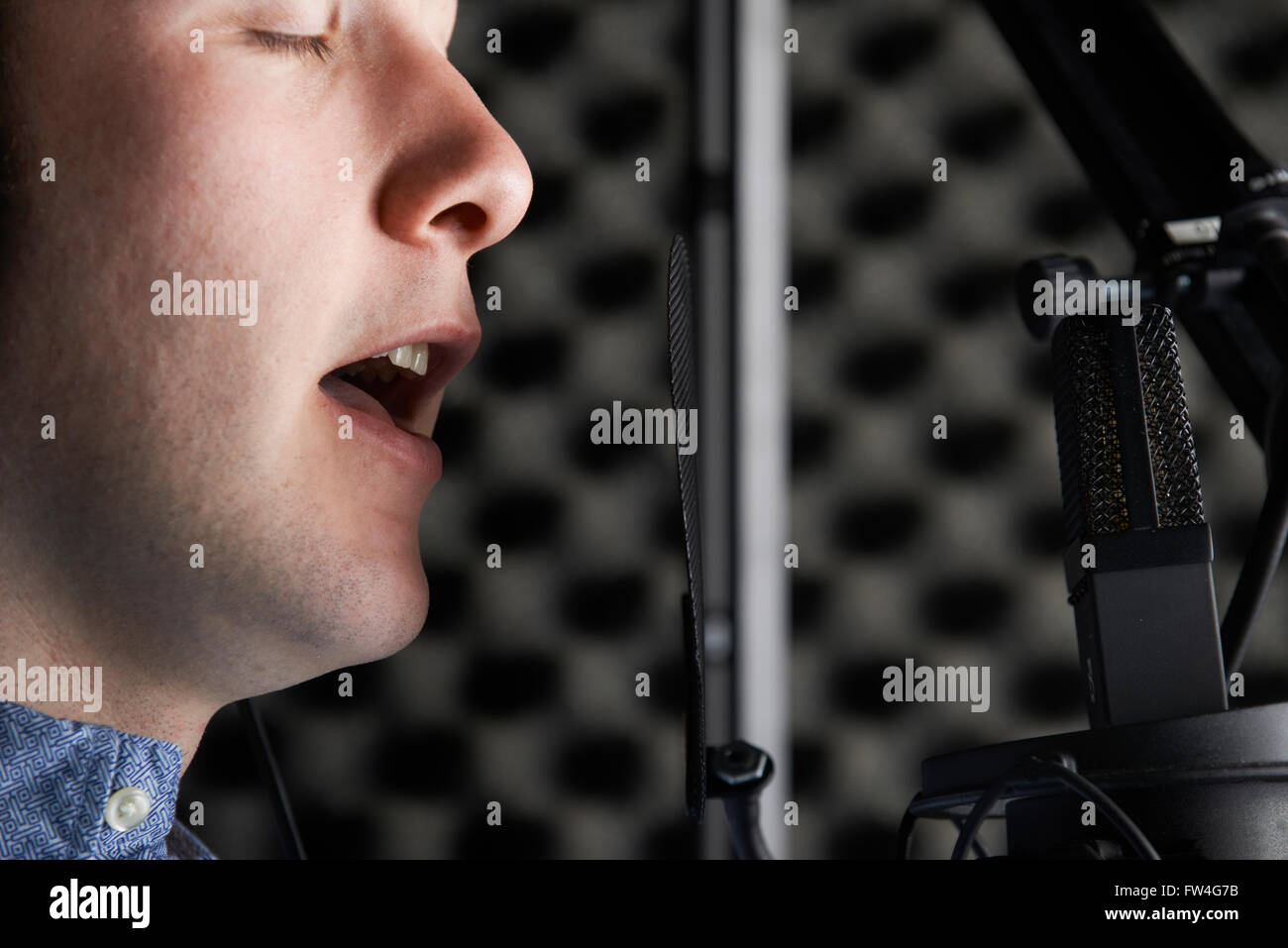 Vocalist maschio con microfono in studio di registrazione Foto Stock