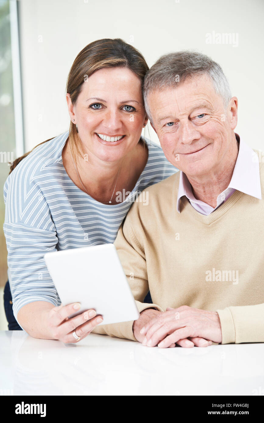 Senior l uomo e la figlia adulta guardando a tavoletta digitale insieme Foto Stock