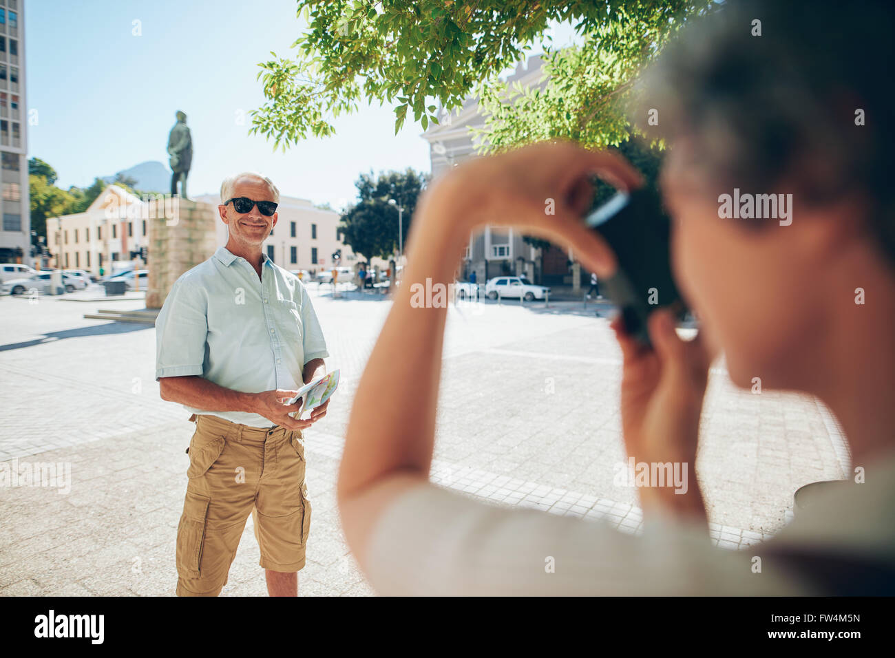 Uomo Senior in posa per una fotografia. L uomo che è fotografata da sua moglie in una vacanza. Foto Stock