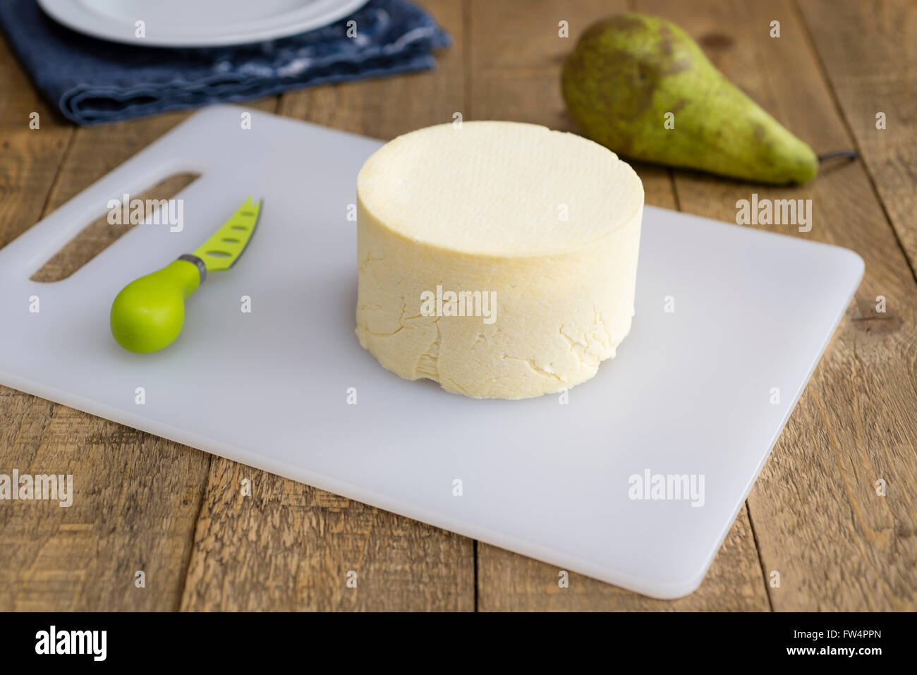 Truckle casereccio formaggio Cheshire su una vecchia cucina in legno tavolo. Foto Stock