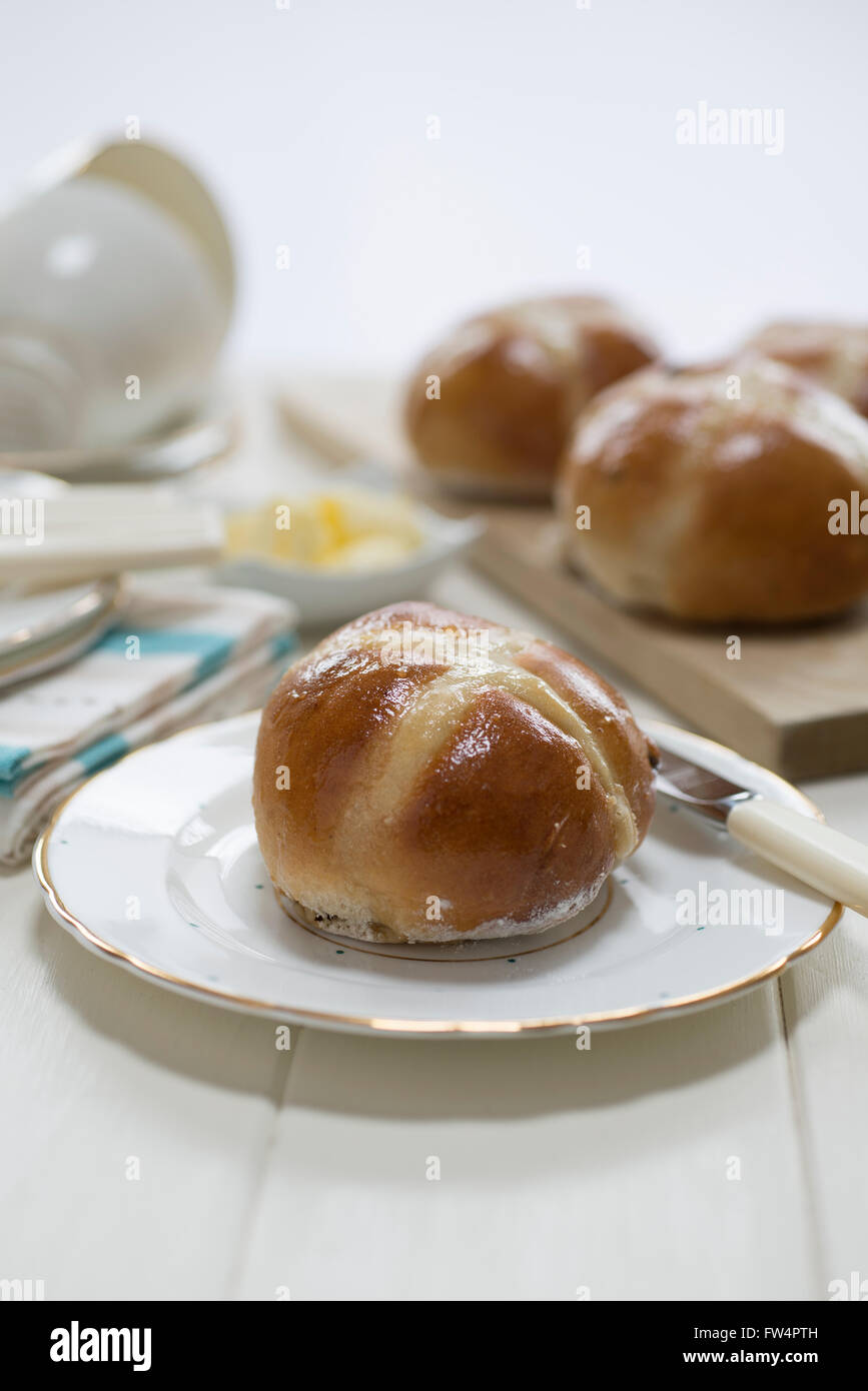 In casa hot cross i panini su una crema verniciato set tavola con raffinati piatti di porcellana cinese e tazze. Foto Stock
