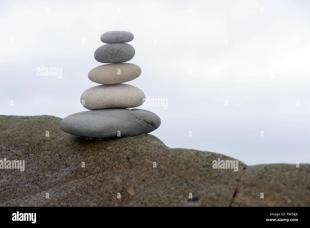 Cinque pietre lisce equilibrio su una roccia a West Coast Beach, Isola del Sud, Nuova Zelanda Foto Stock