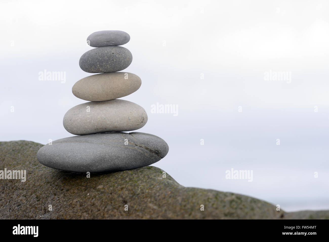 Cinque pietre lisce equilibrio su una roccia a West Coast Beach, Isola del Sud, Nuova Zelanda Foto Stock