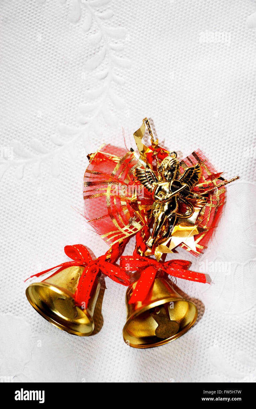 Le campane di Natale, torta o albero decorazione, con angelo che suona il violino, ottone con nastri di colore rosso Foto Stock
