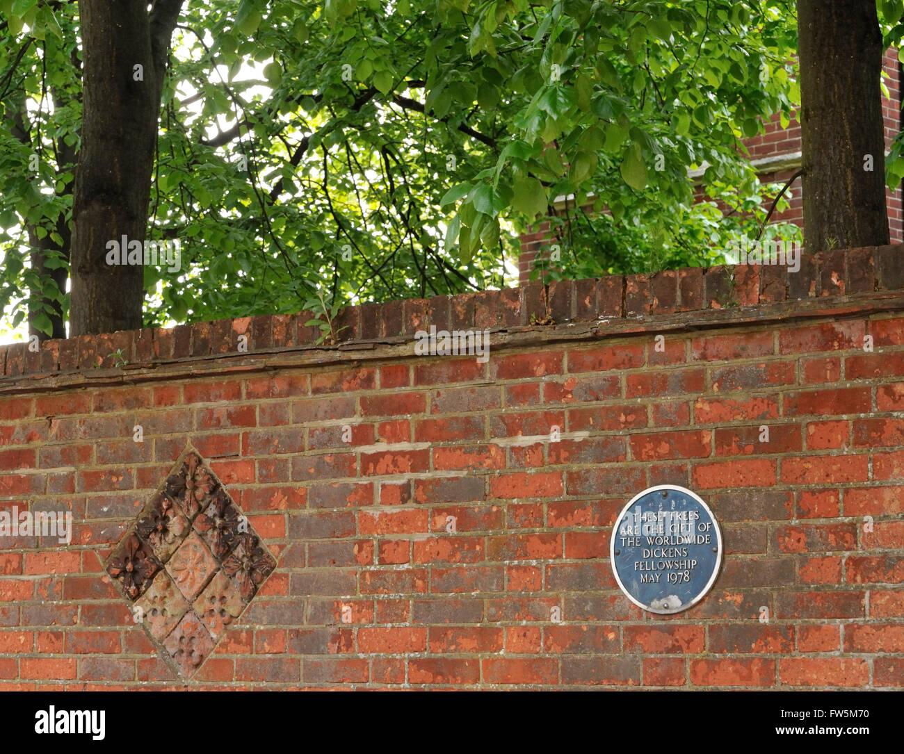 Mattoni ornamentali, georgiano, e targa blu di fronte al Charles Dickens Birthplace Museum; 393 Old commerciale Road, Portsmouth, PO1 4QL. La casa, originariamente "1 Mile End Terrazza' è stata preservata dalla Fellowship da demolizione per la costruzione di strade e gli alberi sono stati piantati per celebrare la conservazione di una appartata strada laterale. Charles Dickens nato il 7 febbraio 1812. Foto Stock