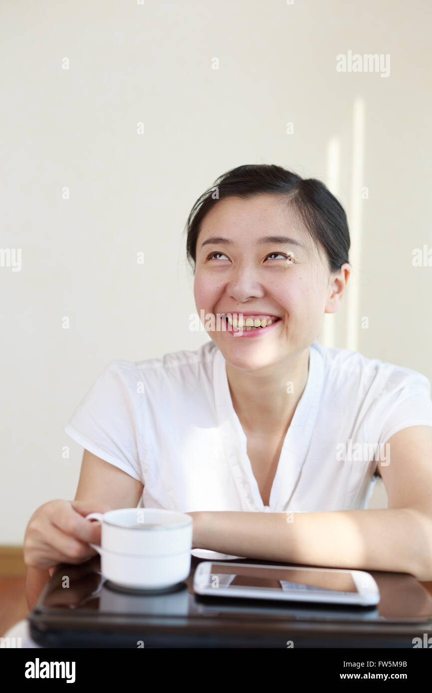 Una donna asiatica in una camicia bianca è ridere. Foto Stock