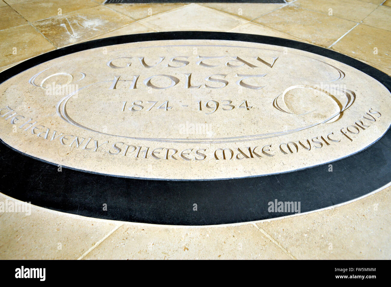 Nuovo, di ricambio, pavimento placca in Chichester Cathedral al compositore inglese Gustav Holst, 1874-1934. Il settantacinquesimo anniversario della morte del compositore Gustav Holst è stata celebrata in un Festival di tre giorni a Chichester Cathedral nel settembre 2009. Holst è il più vicino amico era il vescovo George Bell ed era Bell che ha richiamato a lui di Sussex con la sua Pentecoste cantanti per rendere la musica nella cattedrale e nelle parrocchie intorno a Chichester. Alla sua morte nel 1934, Holst la famiglia ha chiesto se il compositore la cenere potrebbe essere sepolto nella cattedrale, e questo è stato fatto nel transetto Nord, sotto una lapide a Thomas Weelkes Foto Stock