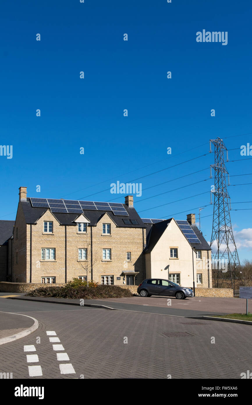 Pannelli solari sui tetti delle case in corrispondenza di un alloggiamento nuovo sviluppo sulla periferia di Cirencester, Gloucestershire, Regno Unito Foto Stock