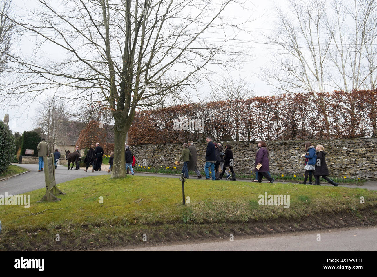 Processione di persone locali con un asino per celebrare la Domenica delle Palme in Southrop, Gloucestershire, Regno Unito Foto Stock