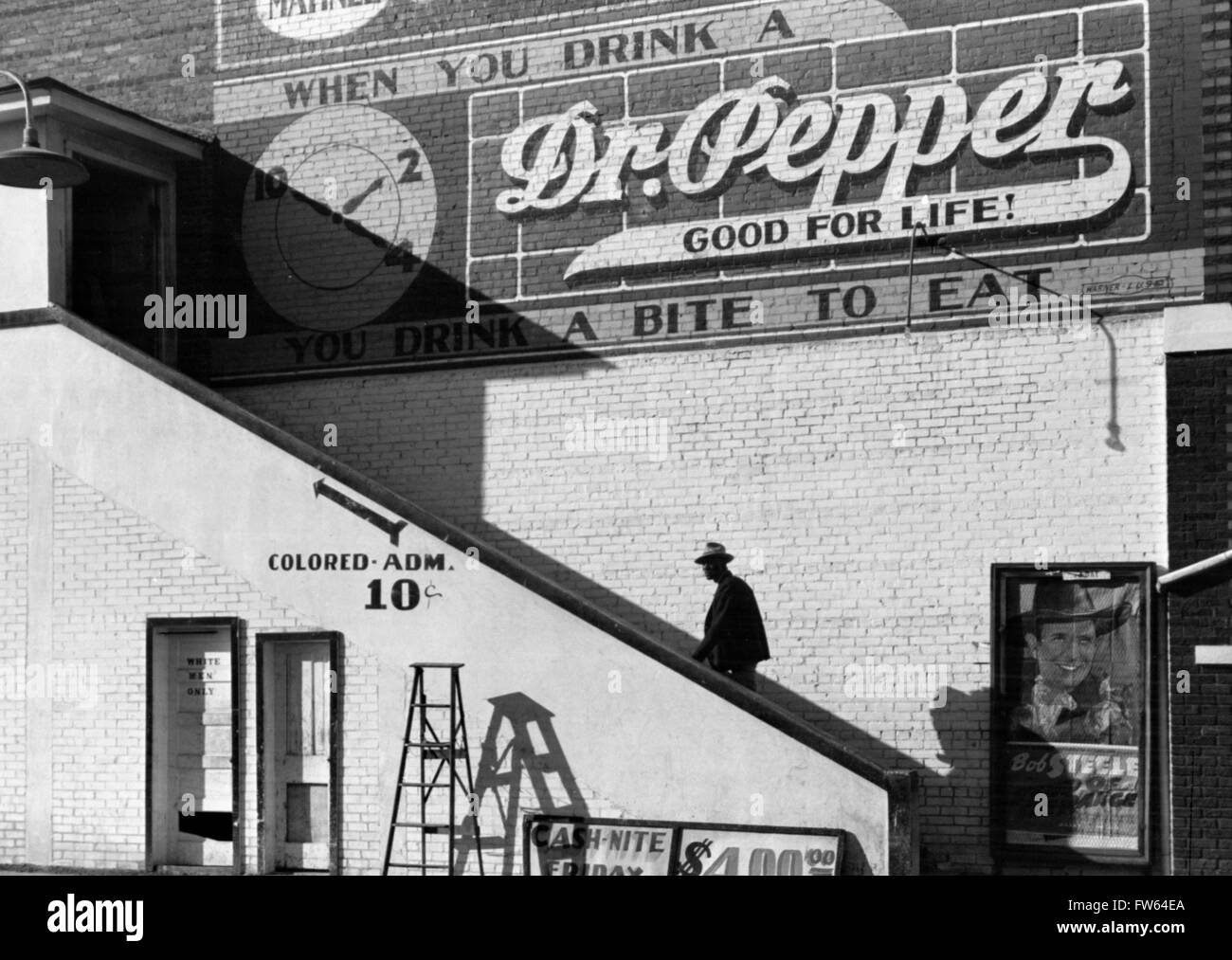 La segregazione razziale. Un uomo nero salendo una scalinata verso il 'colorato' entrata di un cinema con un "Bianco uomini solo' restroom sotto, Belzoni, Mississippi Delta, Mississippi, Stati Uniti d'America. Foto di Marion Post Wolcott, 1939. Foto Stock