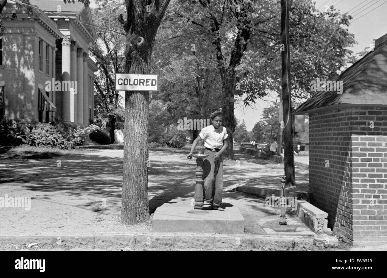 La segregazione, STATI UNITI D'AMERICA. Giovane black boy a bere a una fontana di acqua con un "colorato" segno al di sopra di esso, Halifax, North Carolina, Stati Uniti d'America. Foto di John Vachon, 1938 Foto Stock