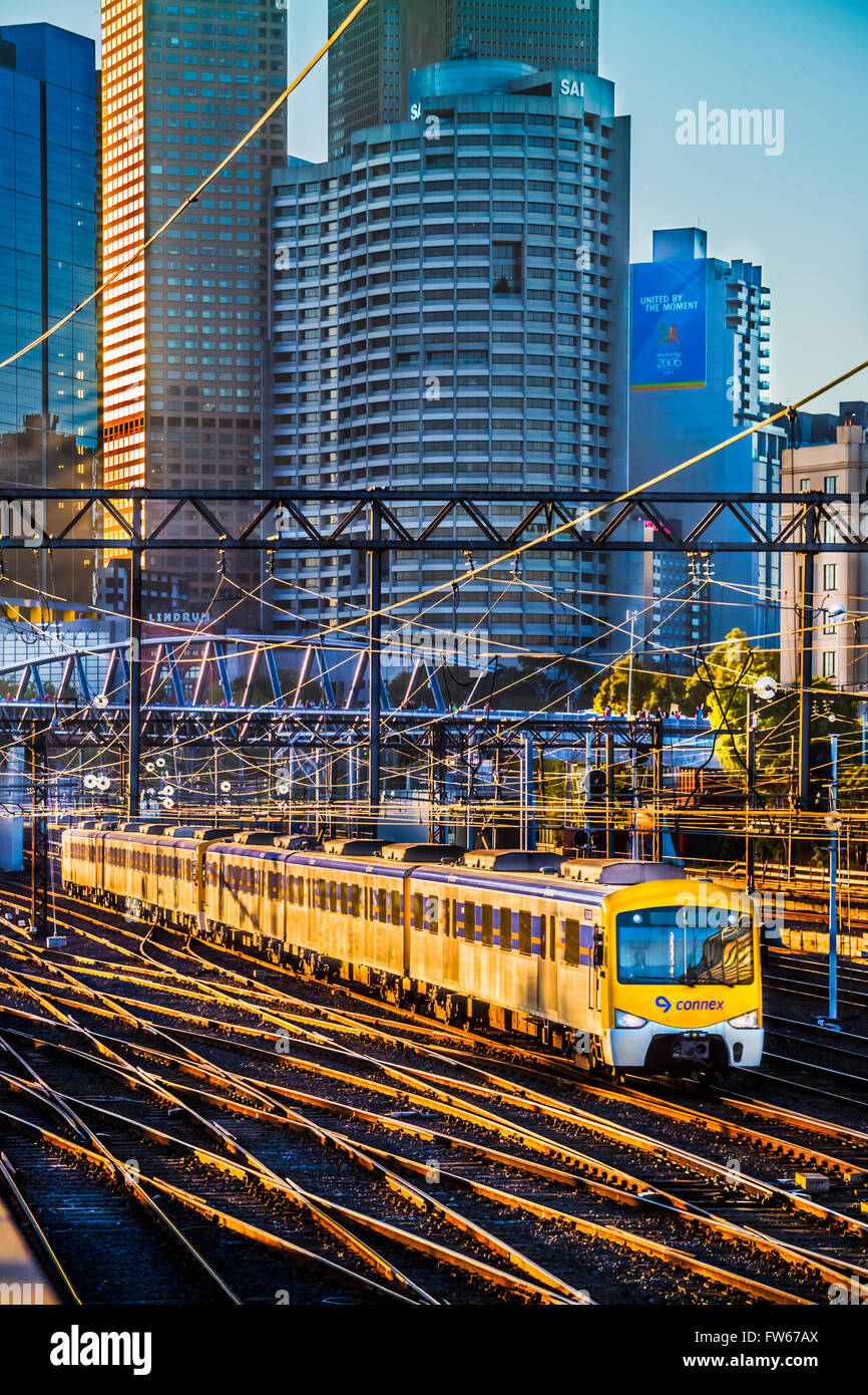 La luce del sole glinting su binari ferroviari, come il treno tira fuori della città di Melbourne in Australia Foto Stock