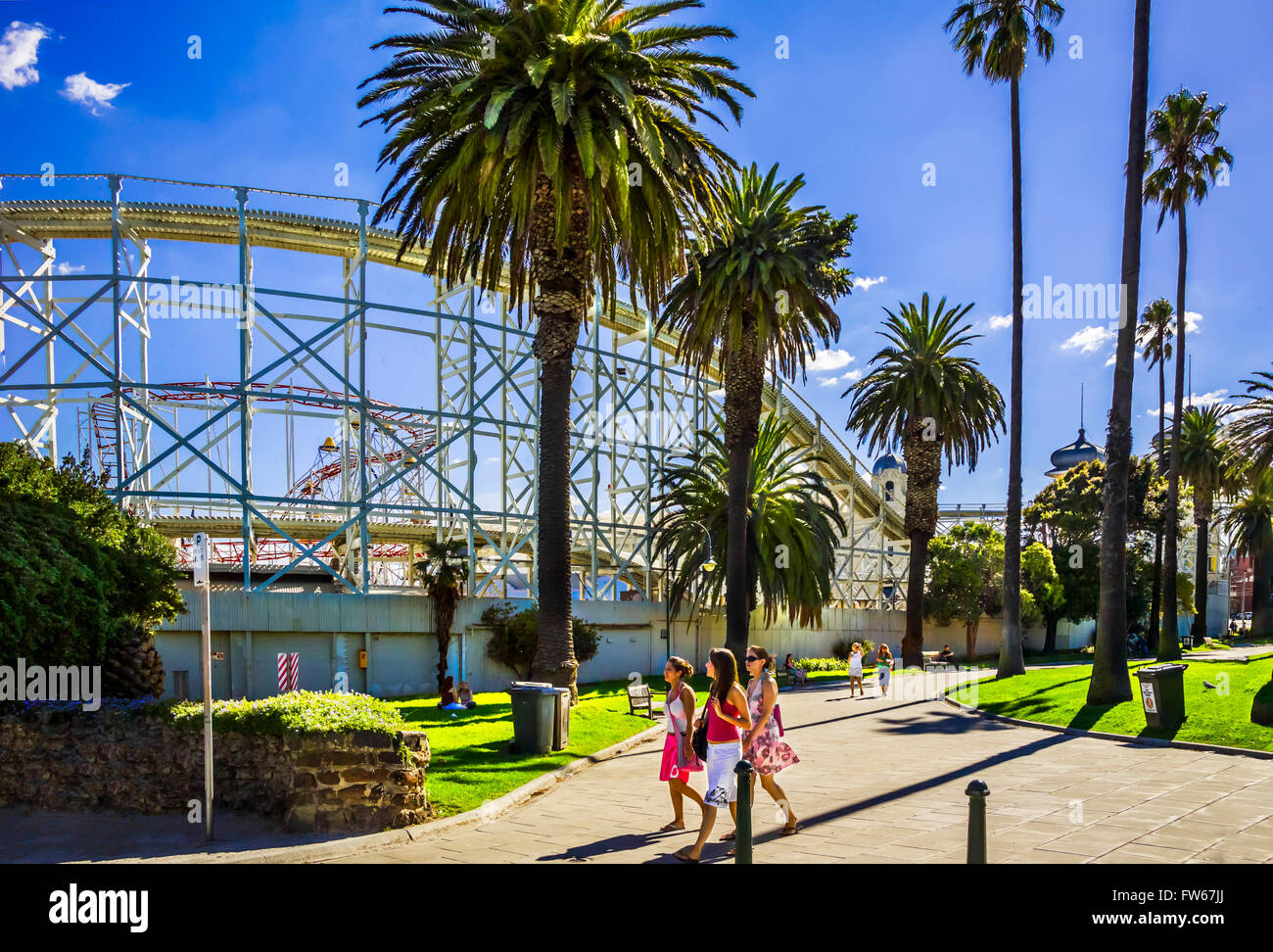 Le giovani ragazze passeggiando nel parco della città, in una calda giornata estiva, vicino al Luna Park, St Kilda, Melbourne Australia Foto Stock