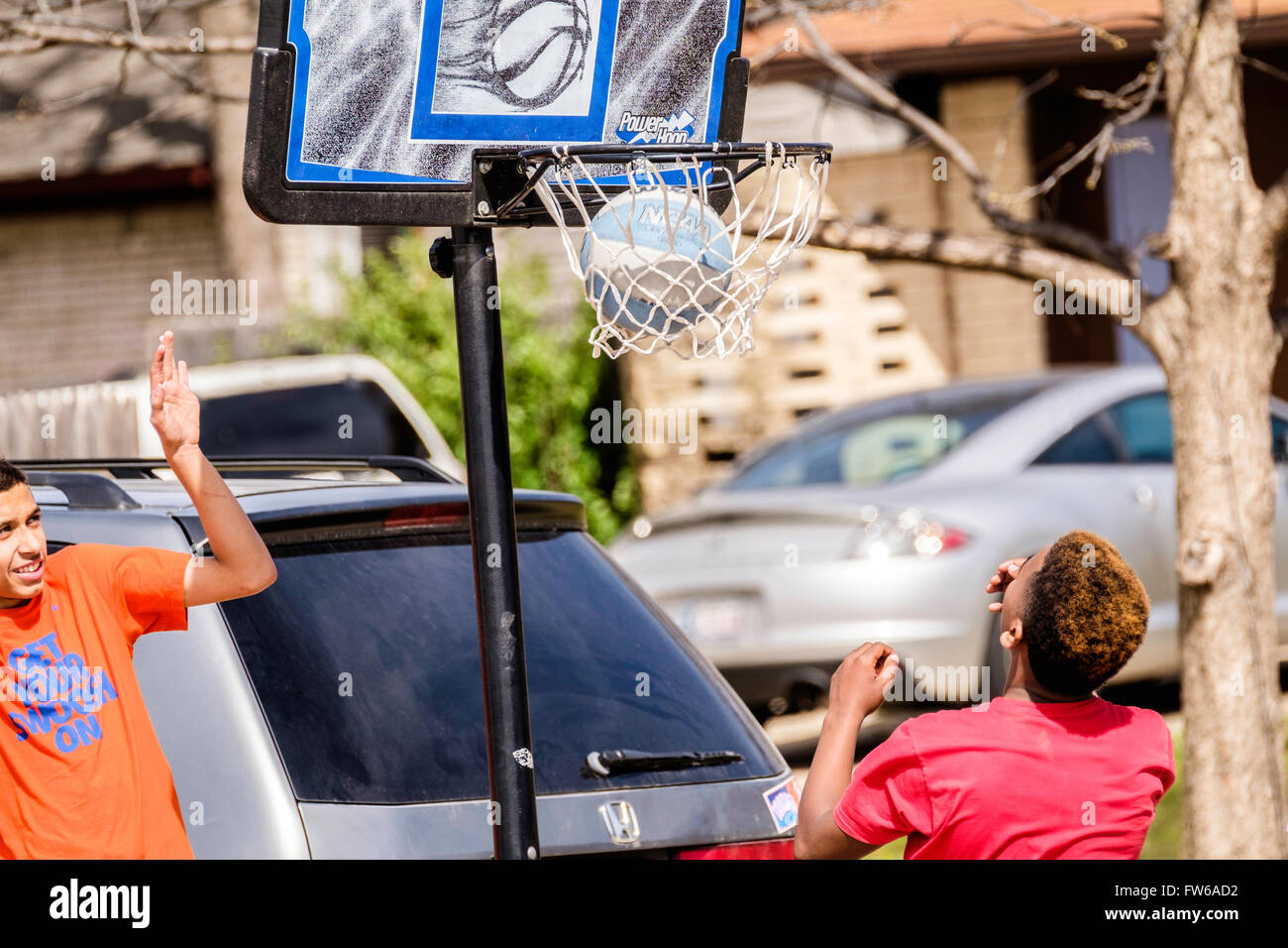Teen e pre-teen boys raccogliere e giocare a basket su strada nella città di Oklahoma, Oklahoma, Stati Uniti d'America. Foto Stock