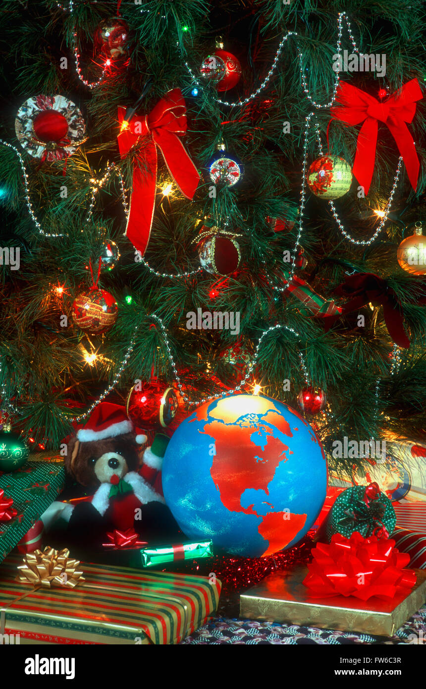 Globo terrestre che mostra il Nord America tra i regali di Natale sotto un albero di Natale Foto Stock