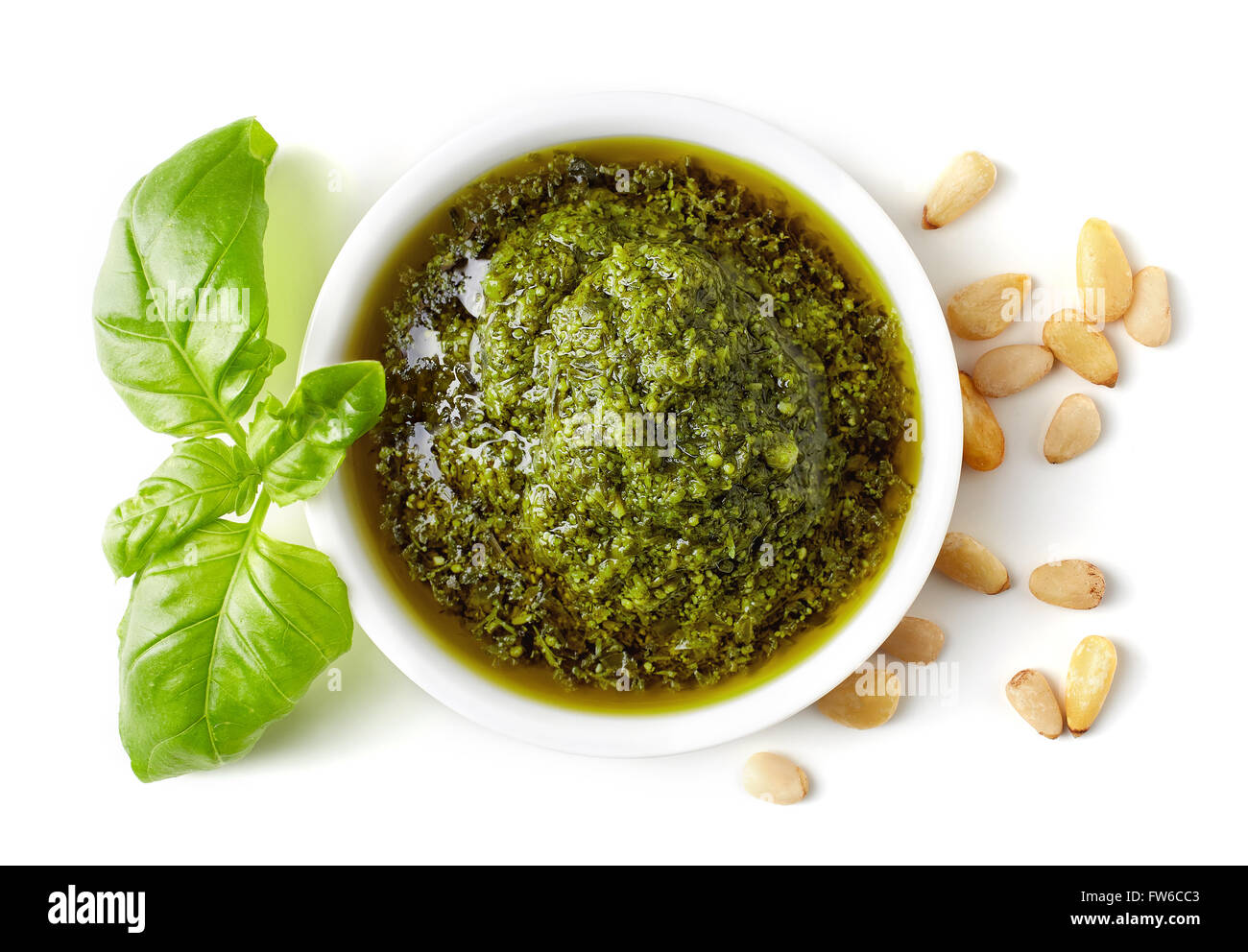 Green pesto, pinoli e basilico isolati su sfondo bianco, vista dall'alto Foto Stock