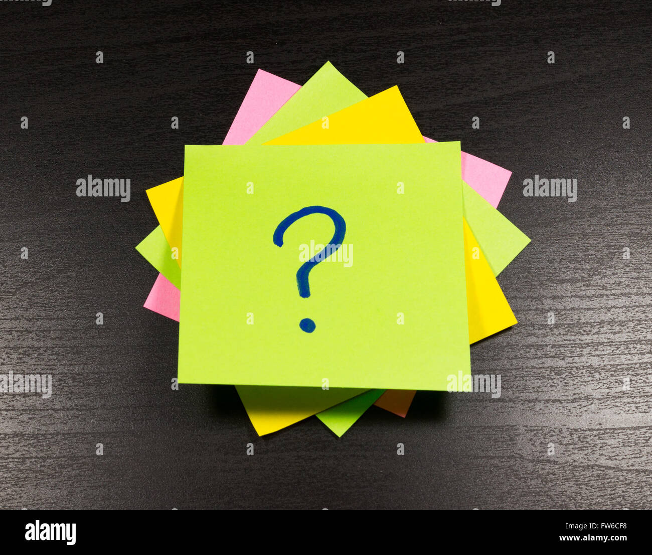 Punto interrogativo su un foglietto adesivo su sfondo di legno Foto Stock