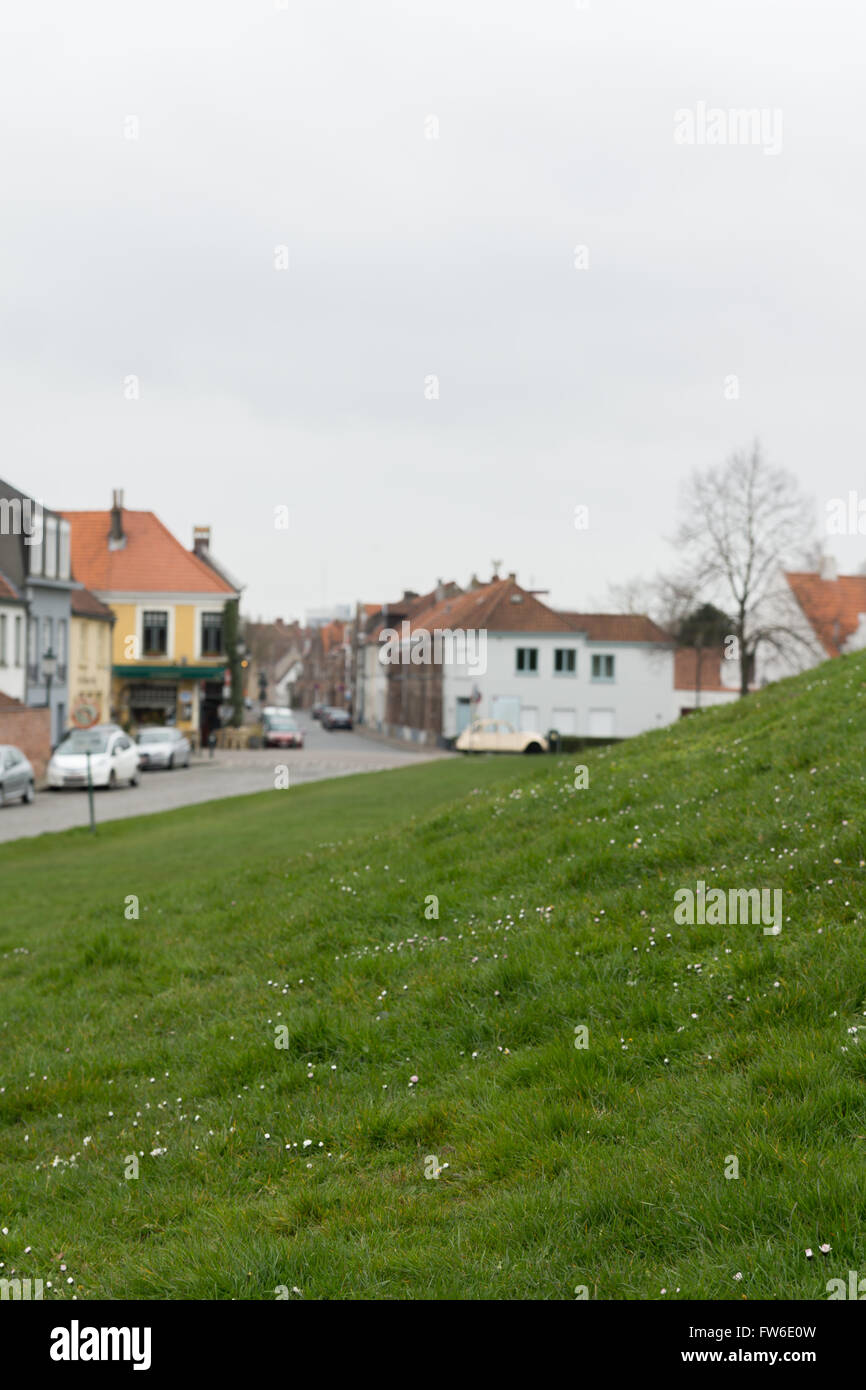 Case in bruges da una verde collina di erba Foto Stock