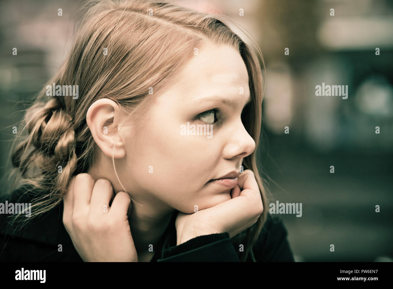 Profilo di un pensieroso giovane donna bionda, dissaturato, grana di pellicola Foto Stock
