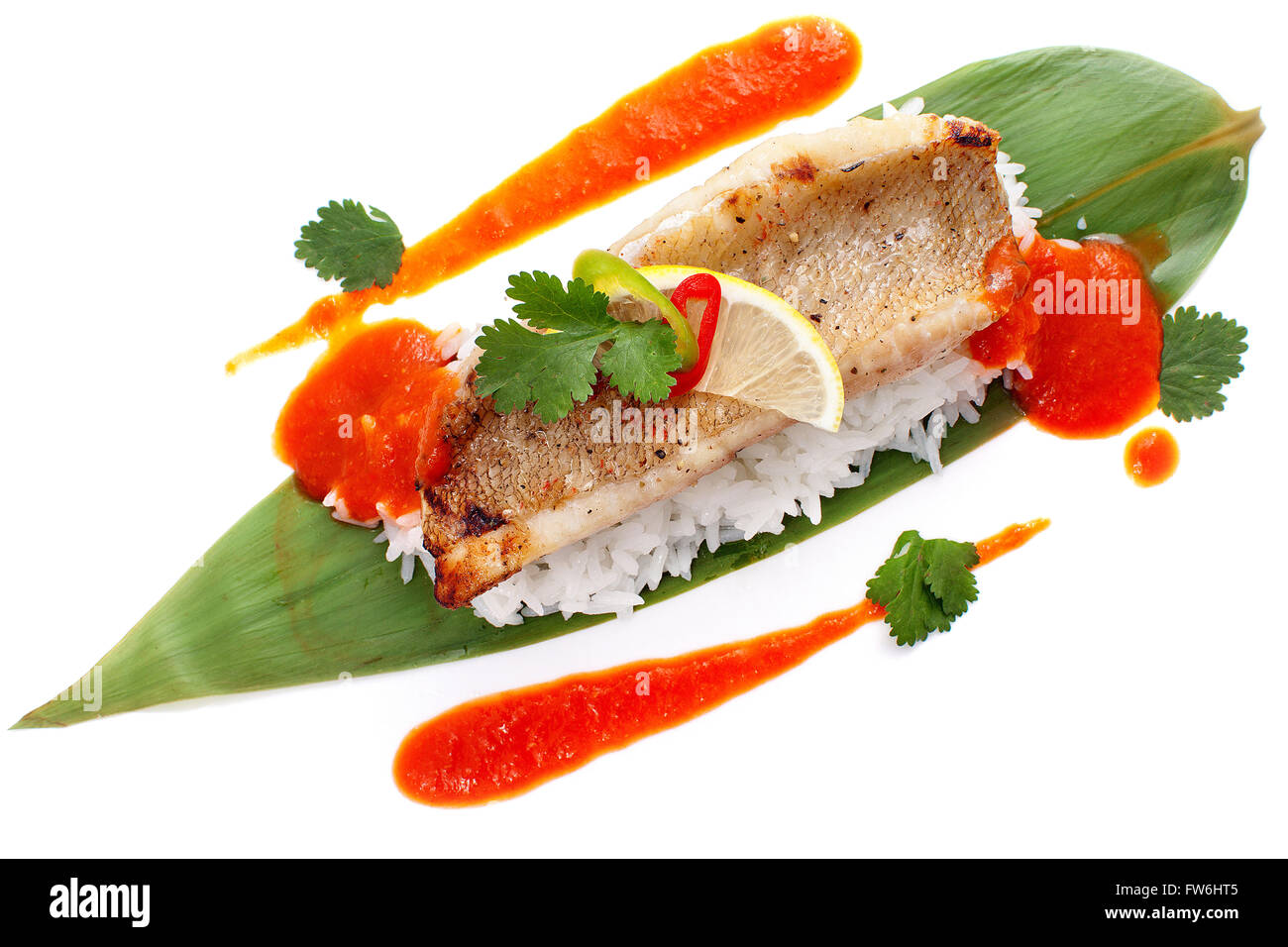Filetti di pesce persico su foglie di bambù con riso e salsa Foto Stock