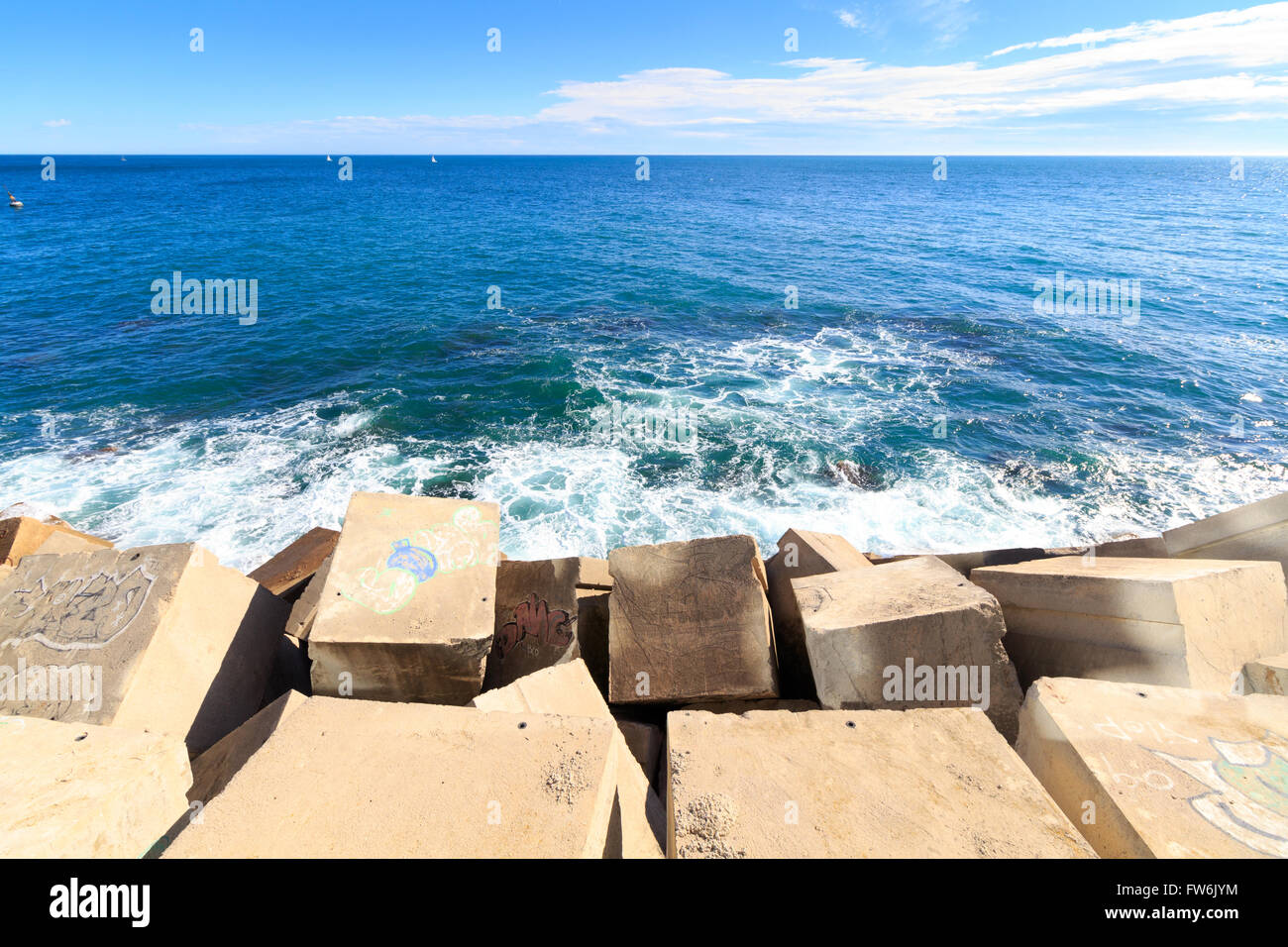 Massello di pietra e la diga di cemento sul mare Foto Stock